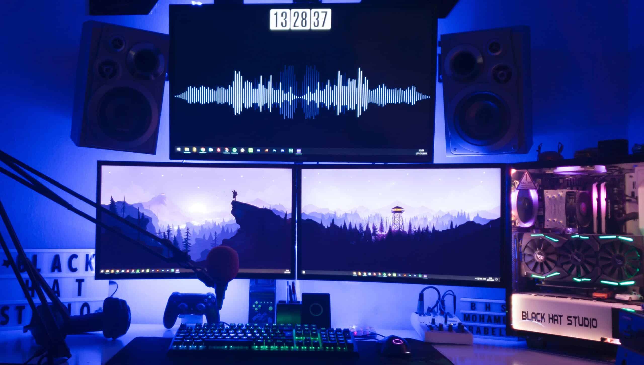 Complete gaming setup with multiple monitors with light purple backlighting.