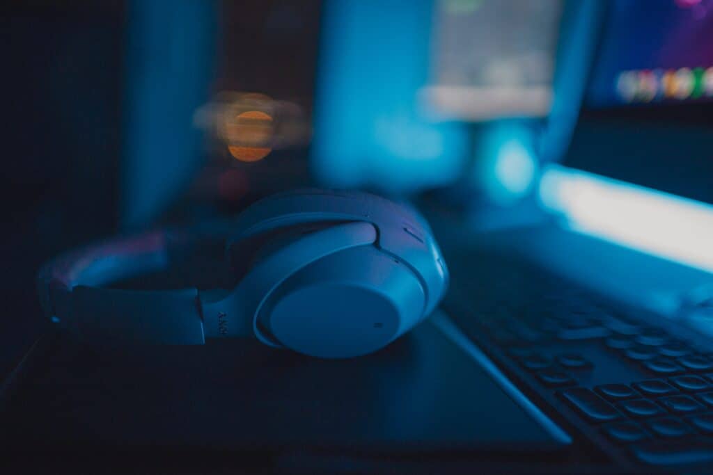 White gaming headset in a dark room with blue lights.